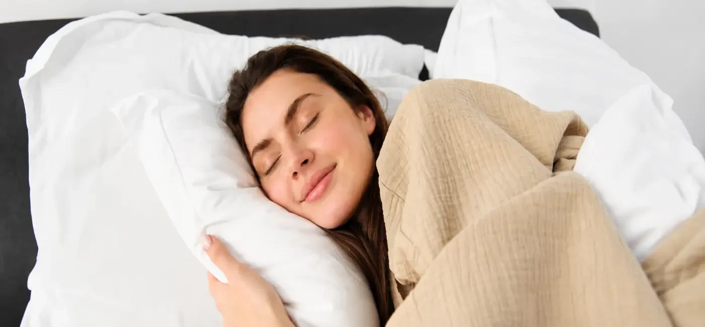 Person sleeping peacefully with noise cancelling sleep buds, demonstrating how sleep buds improve sleep quality, reduce nighttime noise, and support deeper restorative sleep.